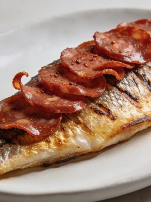 Assiette de cabillaud dore couvert de tranches de chorizo