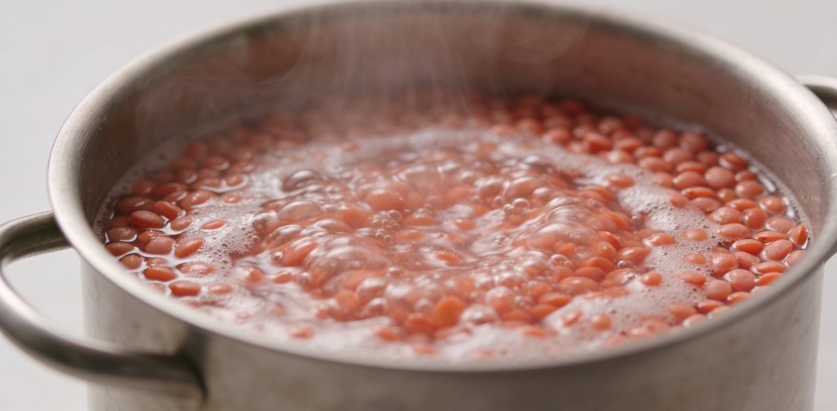 Casserole en metal avec lentilles corail bouillantes
