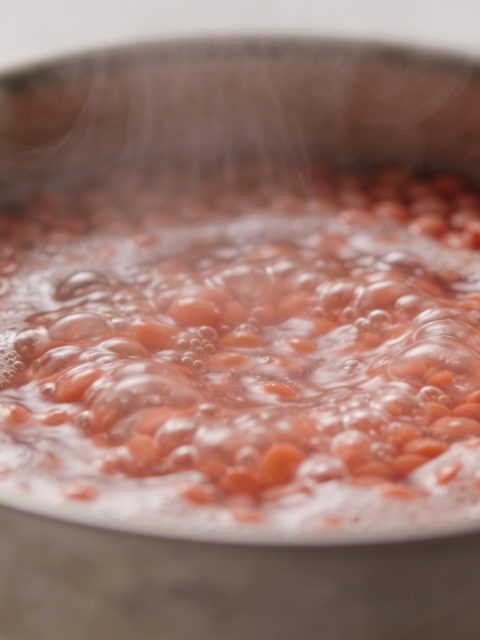 Casserole en metal avec lentilles corail bouillantes