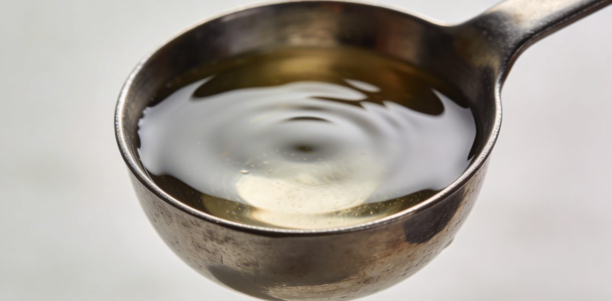 Cuillere doseuse en metal remplie de liquide