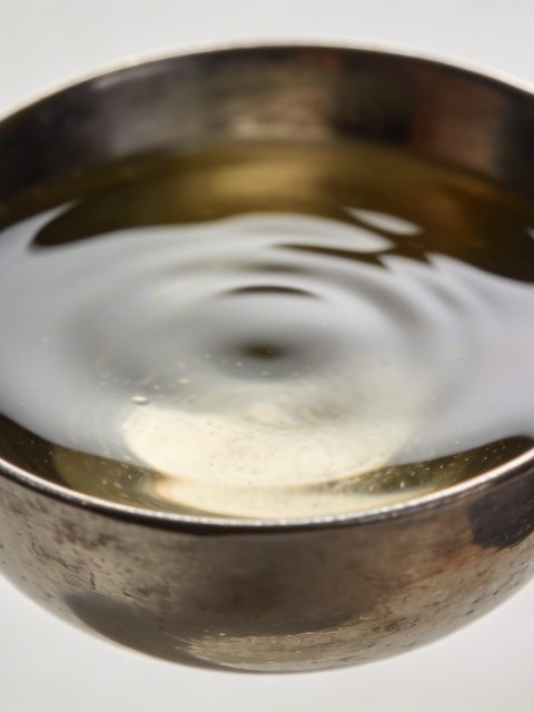 Cuillere doseuse en metal remplie de liquide