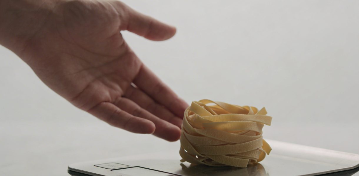 Main tendue vers une balance pesee de pates