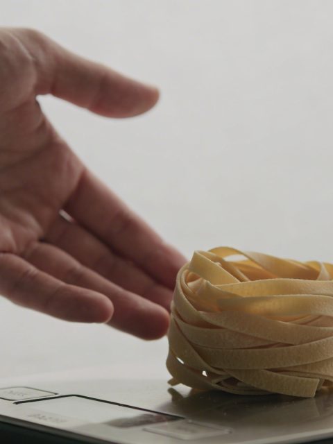 Main tendue vers une balance pesee de pates