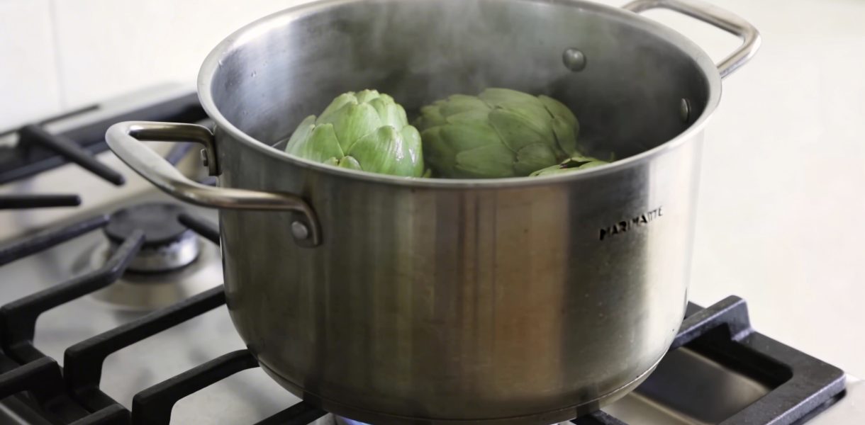 Marmite haute sur gaz avec artichauts verts vapeur