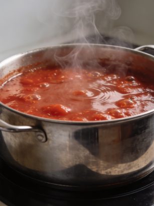Grande marmite de sauce tomate bouillante sur cuisiniere