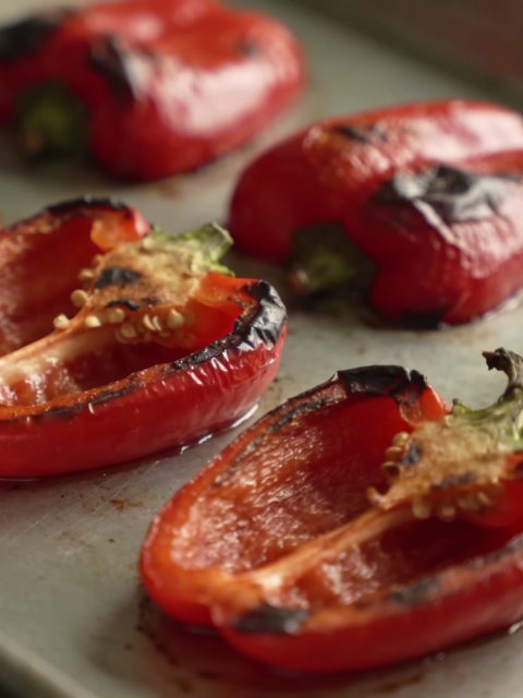 Plat de poivrons rouges grillant sur plaque de four