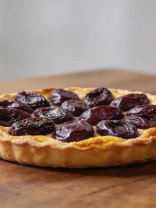 Tarte aux prunes doree sur table en bois