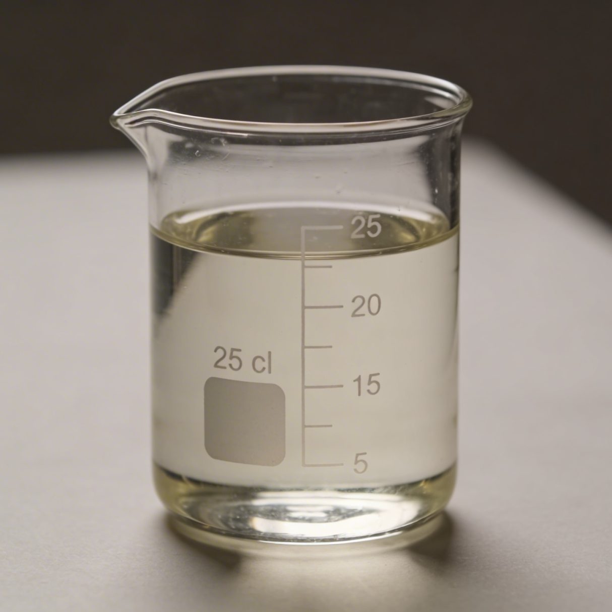 Verre doseur transparent rempli a 25 cl sur table