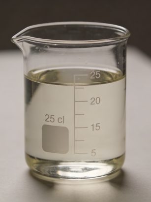 Verre doseur transparent rempli a 25 cl sur table