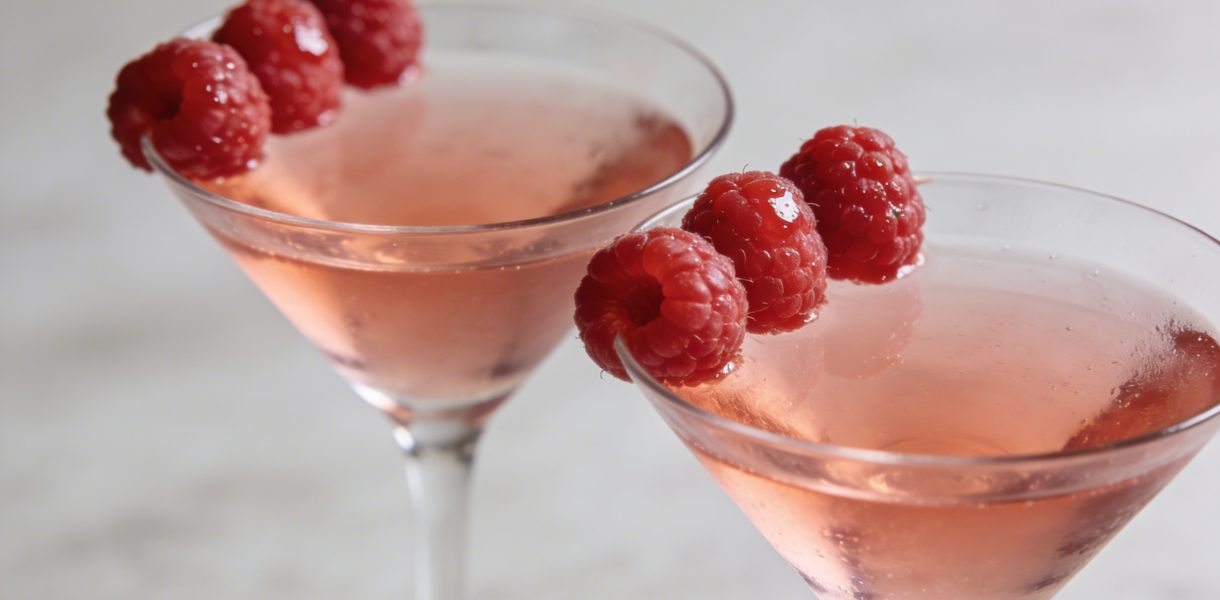 Verres de cocktail roses garnis de framboises fraîches
