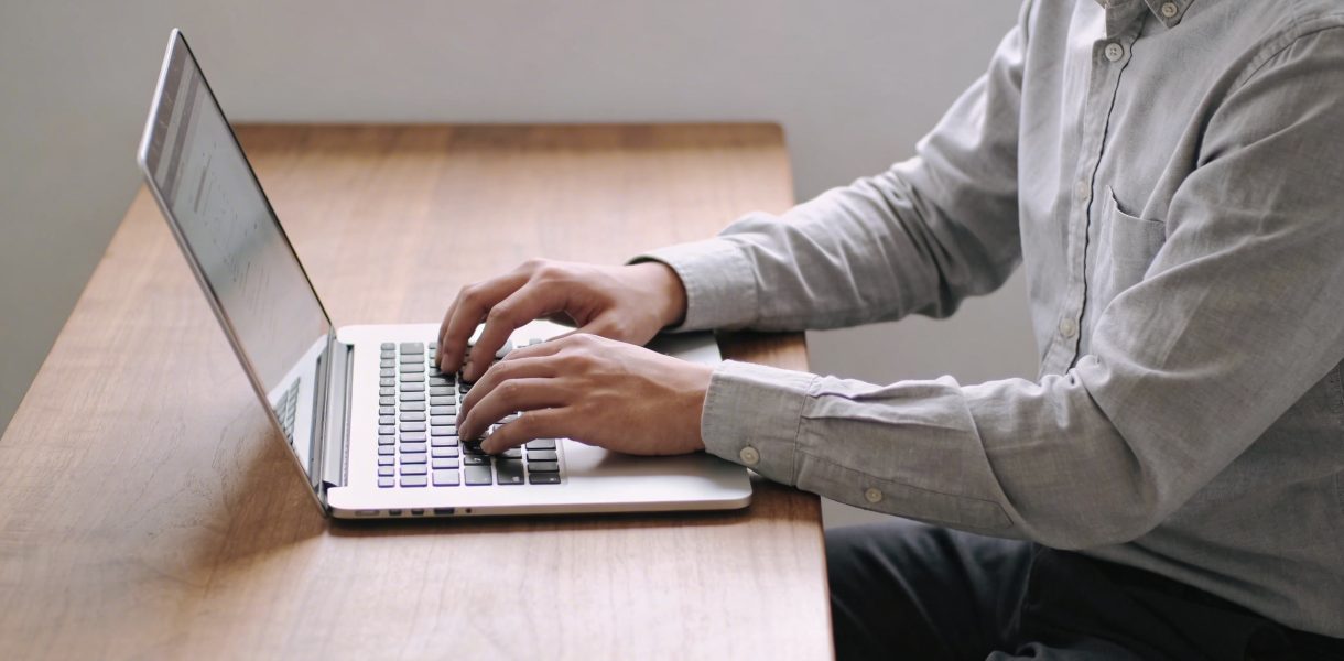 Personne assise a un bureau devant ordinateur