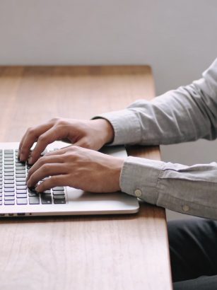 Personne assise a un bureau devant ordinateur